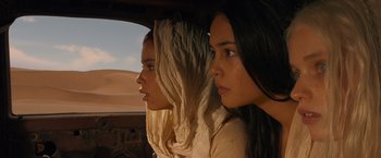 Movie still from “Mad Max: Fury Road” (2015), directed by George Miller – Two young women sitting in the back seat of a car; Close Up shot, Low angle