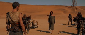 Movie still from “Mad Max: Fury Road” (2015), directed by George Miller – A group of people standing on top of a dirt field; Wide shot, Low angle