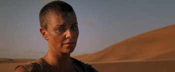 Movie still from “Mad Max: Fury Road” (2015), directed by George Miller – A woman with a shaved head in the desert; Close Up shot, Over the shoulder angle
