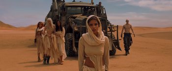 Movie still from “Mad Max: Fury Road” (2015), directed by George Miller – A group of women standing in front of a large truck; Medium shot, Over the shoulder angle