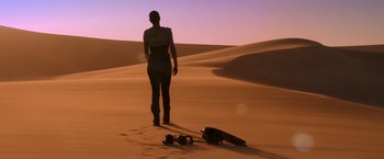 Movie still from “Mad Max: Fury Road” (2015), directed by George Miller – A woman walking in the desert with a guitar case; Wide shot, Low angle