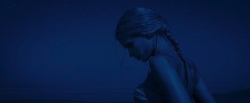 Movie still from “Mad Max: Fury Road” (2015), directed by George Miller – A woman with a braid standing in the dark at night; Close Up shot, Low angle