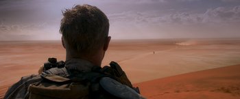 Movie still from “Mad Max: Fury Road” (2015), directed by George Miller – A man looking out over a desert landscape; Extreme Wide shot, Over the shoulder angle