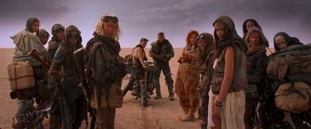 Movie still from “Mad Max: Fury Road” (2015), directed by George Miller – A group of people standing in the desert; Wide shot, High angle