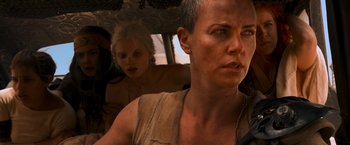 Movie still from “Mad Max: Fury Road” (2015), directed by George Miller – A woman with a shaved head in a vehicle; Close Up shot, Over the shoulder angle