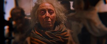 Movie still from “Mad Max: Fury Road” (2015), directed by George Miller – An old woman with white hair and red eyes; Close Up shot, Over the shoulder angle