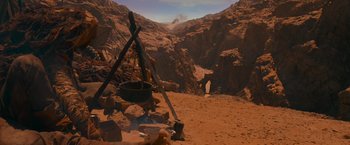 Movie still from “Mad Max: Fury Road” (2015), directed by George Miller – A pot sitting on top of the ground in front of a mountain range; Extreme Wide shot, High angle