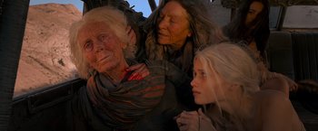 Movie still from “Mad Max: Fury Road” (2015), directed by George Miller – Two women and a girl are praying together; Close Up shot, High angle