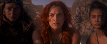 Movie still from “Mad Max: Fury Road” (2015), directed by George Miller – A person with long red hair; Close Up shot, Low angle