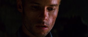 Movie still from “Memento” (2000), directed by Christopher Nolan – A person with a blood trail on his face; Extreme Close Up shot, Low angle