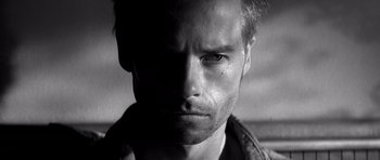 Movie still from “Memento” (2000), directed by Christopher Nolan – Black and white photograph of a man's face; Close Up shot, Low angle