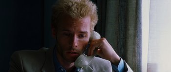 Movie still from “Memento” (2000), directed by Christopher Nolan – A person talking on a phone; Close Up shot, High angle