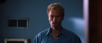 Movie still from “Memento” (2000), directed by Christopher Nolan – A person wearing a blue shirt; Close Up shot, Low angle