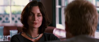 Movie still from “Memento” (2000), directed by Christopher Nolan – A person sitting in a chair; Close Up shot, Over the shoulder angle