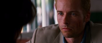 Movie still from “Memento” (2000), directed by Christopher Nolan – A person wearing a suit and tie; Close Up shot, Over the shoulder angle
