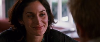 Movie still from “Memento” (2000), directed by Christopher Nolan – A person smiling; Close Up shot, Over the shoulder angle