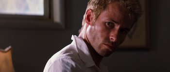 Movie still from “Memento” (2000), directed by Christopher Nolan – A person wearing a white shirt; Close Up shot, Low angle