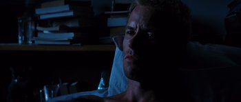 Movie still from “Memento” (2000), directed by Christopher Nolan – A person in a dark room; Close Up shot, High angle