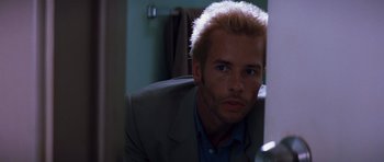 Movie still from “Memento” (2000), directed by Christopher Nolan – A person wearing a suit and tie; Close Up shot, Low angle