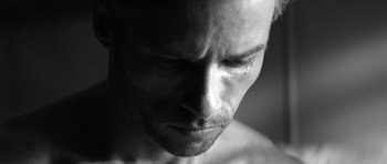 Movie still from “Memento” (2000), directed by Christopher Nolan – Black and white photograph of a man's face; Extreme Close Up shot, Low angle