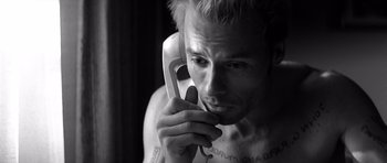 Movie still from “Memento” (2000), directed by Christopher Nolan – A man holding a phone up to his ear; Close Up shot, High angle