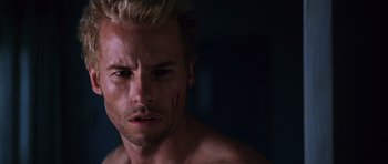 Movie still from “Memento” (2000), directed by Christopher Nolan – A person with a scar on his face; Close Up shot, Low angle