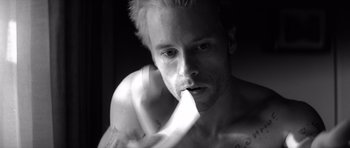 Movie still from “Memento” (2000), directed by Christopher Nolan – Black and white photograph of a man with a towel in his mouth; Close Up shot, High angle