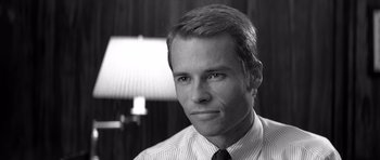 Movie still from “Memento” (2000), directed by Christopher Nolan – Black and white photograph of a man in a dress shirt and tie; Close Up shot, Low angle