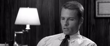 Movie still from “Memento” (2000), directed by Christopher Nolan – Black and white photograph of a man wearing a tie; Close Up shot, Over the shoulder angle