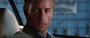 Movie still from “Memento” (2000), directed by Christopher Nolan – A person wearing a suit and tie; Close Up shot, Low angle
