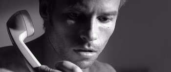 Movie still from “Memento” (2000), directed by Christopher Nolan – Black and white photograph of a young man looking into the distance; Extreme Close Up shot, Low angle