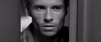 Movie still from “Memento” (2000), directed by Christopher Nolan – Black and white close up of a man's face; Close Up shot, Over the shoulder angle