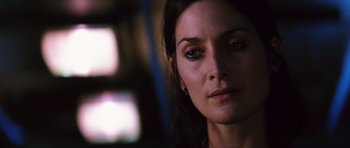 Movie still from “Memento” (2000), directed by Christopher Nolan – A woman's face in a dimly - lit room; Close Up shot, Low angle