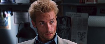 Movie still from “Memento” (2000), directed by Christopher Nolan – A person wearing a suit and tie; Close Up shot, Low angle