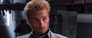 Movie still from “Memento” (2000), directed by Christopher Nolan – A person wearing a suit and tie; Close Up shot, Low angle