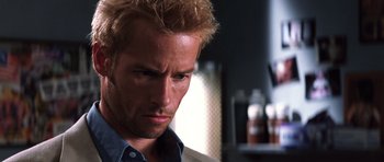 Movie still from “Memento” (2000), directed by Christopher Nolan – A person wearing a blue shirt; Close Up shot, Low angle
