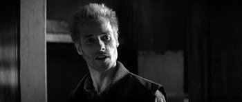 Movie still from “Memento” (2000), directed by Christopher Nolan – Black and white photograph of a man with spiky hair; Close Up shot, Low angle