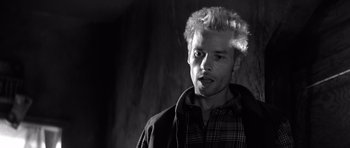 Movie still from “Memento” (2000), directed by Christopher Nolan – Black and white photograph of a man with white hair; Close Up shot, Low angle