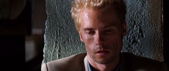 Movie still from “Memento” (2000), directed by Christopher Nolan – A person wearing a suit and tie; Close Up shot, Overhead angle