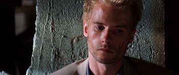 Movie still from “Memento” (2000), directed by Christopher Nolan – A person wearing a suit and tie; Close Up shot, High angle