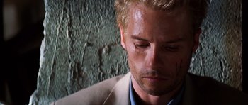 Movie still from “Memento” (2000), directed by Christopher Nolan – A person wearing a suit; Close Up shot, High angle