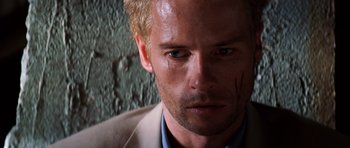 Movie still from “Memento” (2000), directed by Christopher Nolan – A person wearing a suit; Close Up shot, Low angle