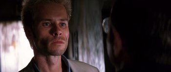 Movie still from “Memento” (2000), directed by Christopher Nolan – A man in a white shirt is looking at another man; Close Up shot, Over the shoulder angle