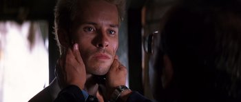 Movie still from “Memento” (2000), directed by Christopher Nolan – A person putting on a necktie; Close Up shot, Over the shoulder angle