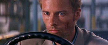 Movie still from “Memento” (2000), directed by Christopher Nolan – A person holding a steering wheel; Close Up shot, High angle