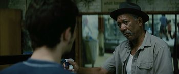 Movie still from “Million Dollar Baby” (2004), directed by Clint Eastwood – A man in a hat is holding a video game controller; Close Up shot, Over the shoulder angle