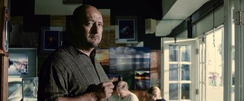 Movie still from “Million Dollar Baby” (2004), directed by Clint Eastwood – A man holding a paintbrush standing in front of a painting; Close Up shot, Low angle