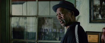 Movie still from “Million Dollar Baby” (2004), directed by Clint Eastwood – An older man wearing a black hat and looking at the camera; Close Up shot, Over the shoulder angle