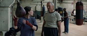 Movie still from “Million Dollar Baby” (2004), directed by Clint Eastwood – A man and a woman in a boxing ring; Medium shot, Low angle
