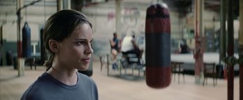 Movie still from “Million Dollar Baby” (2004), directed by Clint Eastwood – A woman standing next to a punching bag in a gym; Close Up shot, Over the shoulder angle